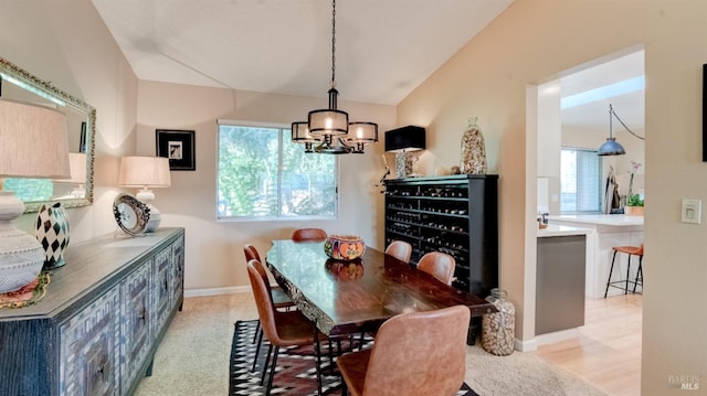 dining space with vaulted ceiling, a notable chandelier, plenty of natural light, and baseboards