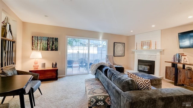 living area with recessed lighting, baseboards, light carpet, and a glass covered fireplace