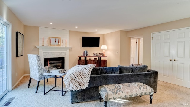 living area featuring a high end fireplace, visible vents, baseboards, light carpet, and recessed lighting
