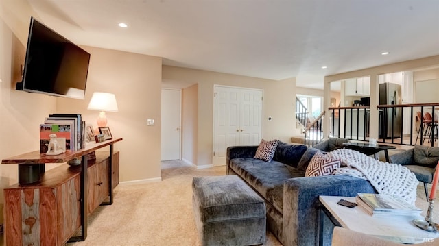 living area featuring recessed lighting, light colored carpet, stairway, and baseboards