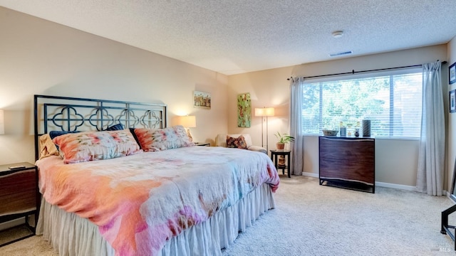 carpeted bedroom featuring visible vents, baseboards, and a textured ceiling