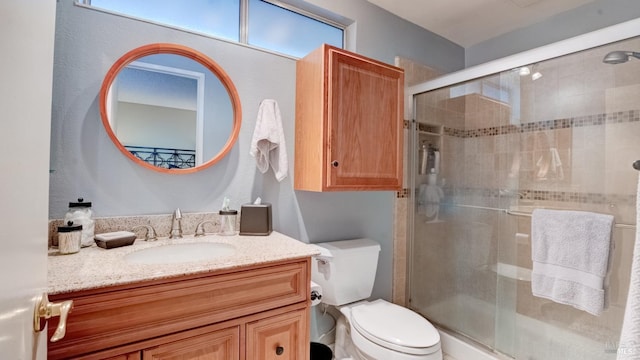 full bathroom featuring toilet, a stall shower, and vanity