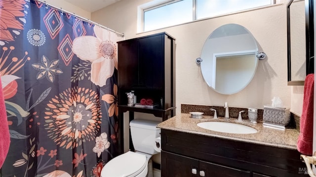 bathroom with toilet, curtained shower, and vanity
