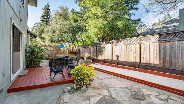 wooden deck with a fenced backyard