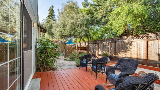 wooden terrace with a fenced backyard and a patio area