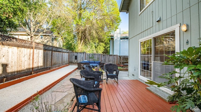wooden terrace with a fenced backyard and outdoor lounge area