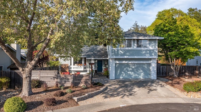 view of front of property with driveway, a garage, and fence