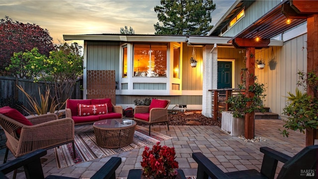 patio terrace at dusk featuring fence and an outdoor hangout area