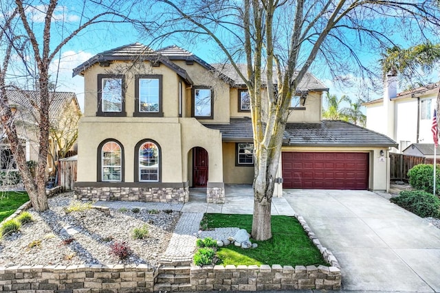 view of front of home with fence, a tiled roof, concrete driveway, stucco siding, and a garage