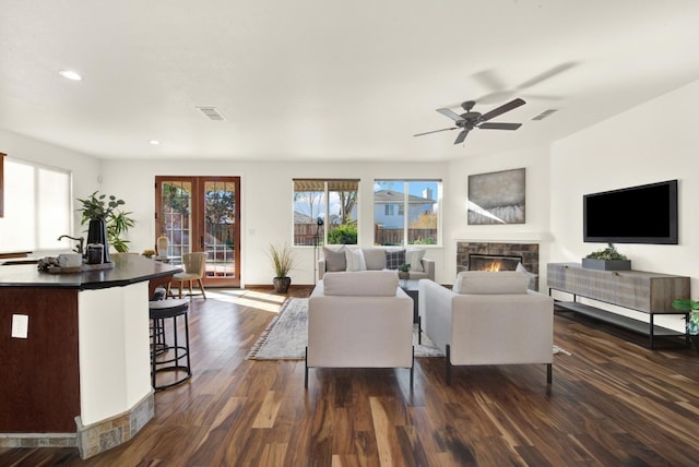 living room featuring dark wood finished floors, recessed lighting, a fireplace, and visible vents