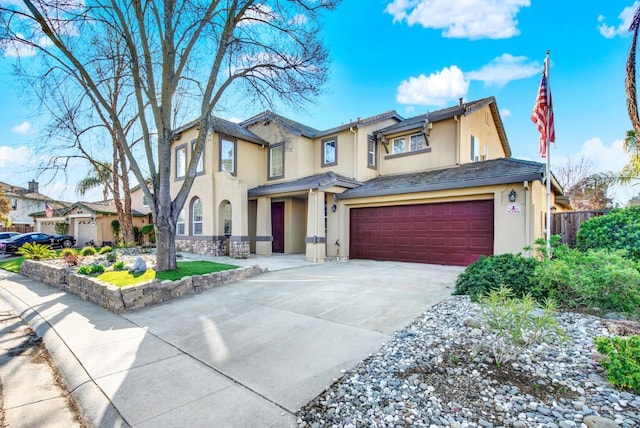 view of front of house with stucco siding, concrete driveway, a garage, and fence