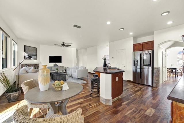 dining room with visible vents, dark wood finished floors, recessed lighting, arched walkways, and ceiling fan