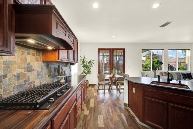 kitchen with visible vents, premium range hood, a sink, black gas cooktop, and dark countertops