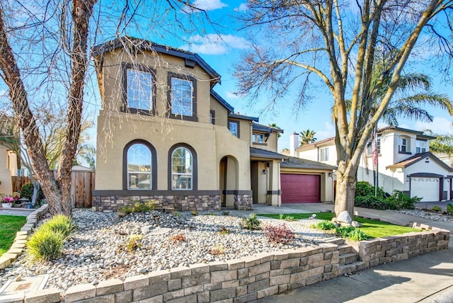 view of front of house featuring fence, stucco siding, a garage, stone siding, and driveway