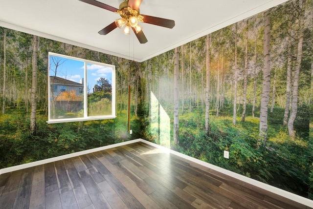 empty room with a ceiling fan, wood finished floors, and baseboards