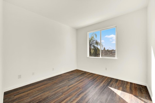 empty room with dark wood-style floors and baseboards