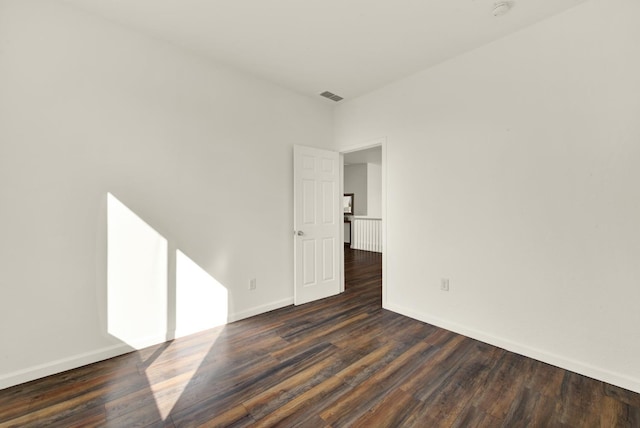 empty room with visible vents, baseboards, and wood finished floors