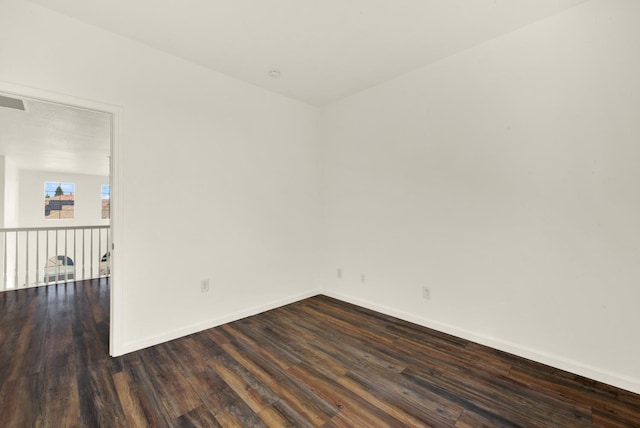 empty room with dark wood finished floors and baseboards