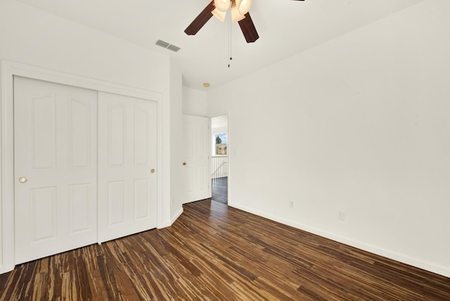 unfurnished bedroom featuring visible vents, baseboards, wood finished floors, a closet, and a ceiling fan