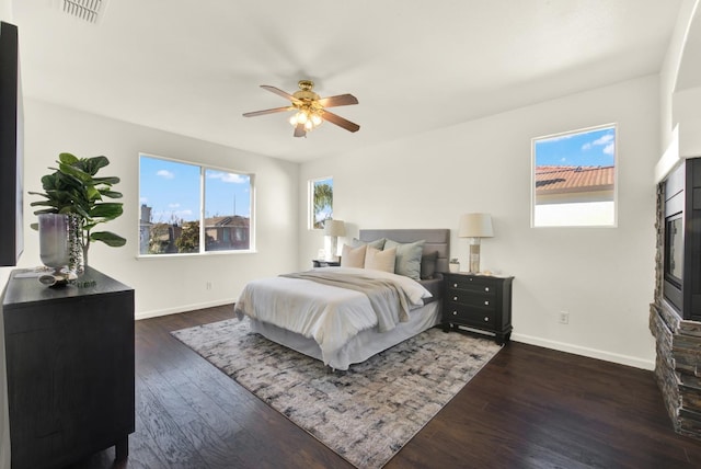 bedroom featuring dark wood-style floors, visible vents, and multiple windows