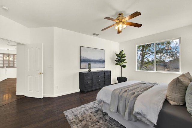 bedroom featuring visible vents, a ceiling fan, baseboards, and wood finished floors