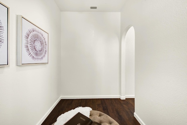 spare room featuring visible vents, baseboards, and wood finished floors