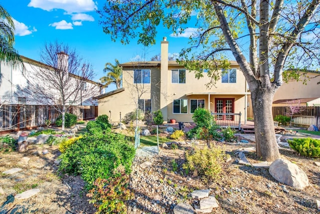 rear view of property featuring a deck, a fenced backyard, and stucco siding