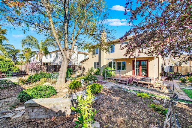 back of property featuring a wooden deck, fence, and stucco siding