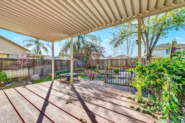 wooden terrace with a fenced backyard