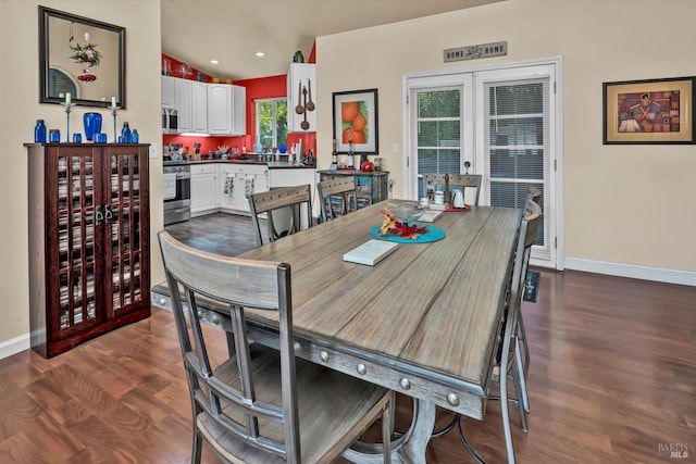 dining area with baseboards, dark wood-style flooring, and vaulted ceiling