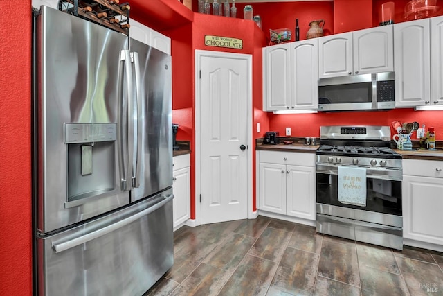 kitchen featuring dark countertops, appliances with stainless steel finishes, and white cabinetry