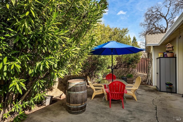 view of patio with outdoor dining space and fence