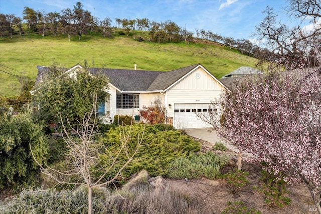 ranch-style house featuring a front lawn, a garage, and a shingled roof