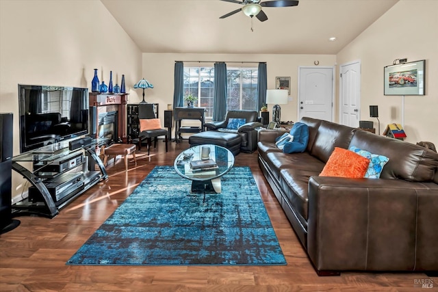 living area with lofted ceiling, wood finished floors, a fireplace, and ceiling fan