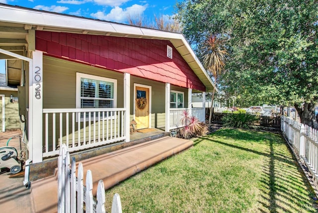 view of front of home featuring a porch, fence, and a front yard