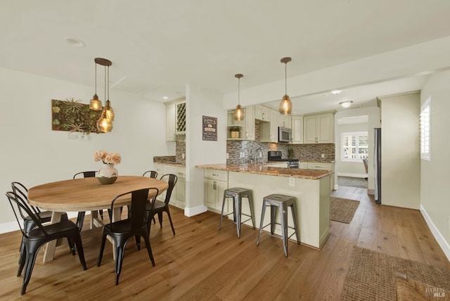 dining space featuring light wood-type flooring and baseboards