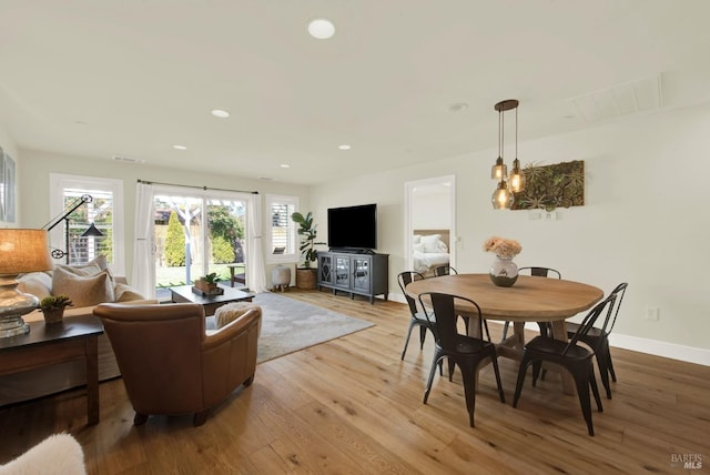 living area with recessed lighting, visible vents, baseboards, and wood finished floors