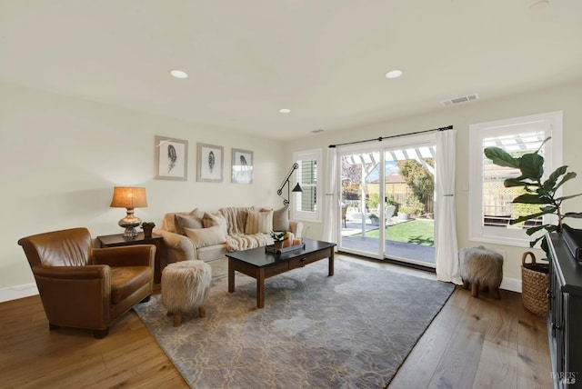 living area featuring recessed lighting, visible vents, and wood-type flooring