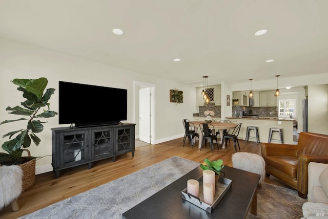 living area featuring recessed lighting, baseboards, and wood finished floors