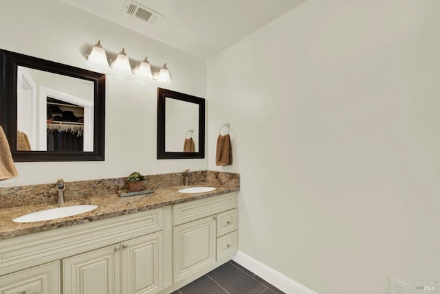 full bath featuring double vanity, visible vents, and a sink