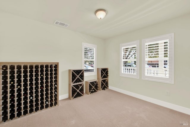 wine area featuring visible vents, baseboards, and carpet