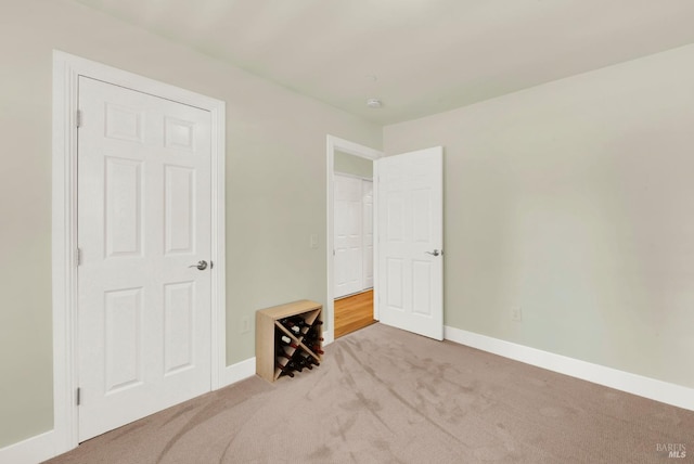 unfurnished bedroom with carpet flooring and baseboards