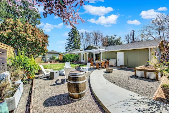 view of yard featuring a garden, a fire pit, fence private yard, and a patio area