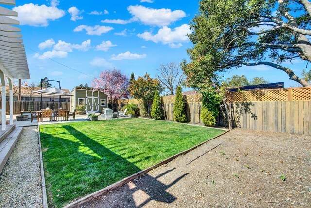 view of yard featuring a fenced backyard, an outdoor hangout area, an outdoor structure, and a patio