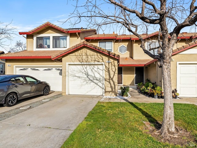 view of front of house with stucco siding, a tiled roof, and concrete driveway