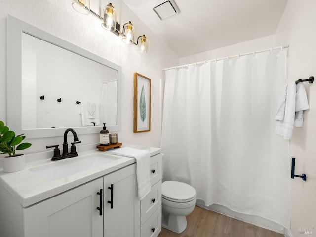 full bathroom featuring a shower with curtain, wood finished floors, toilet, and vanity