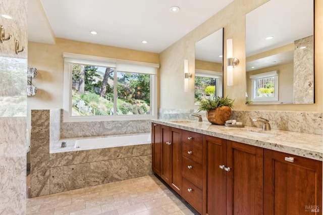 bathroom featuring a sink, recessed lighting, a bath, and double vanity