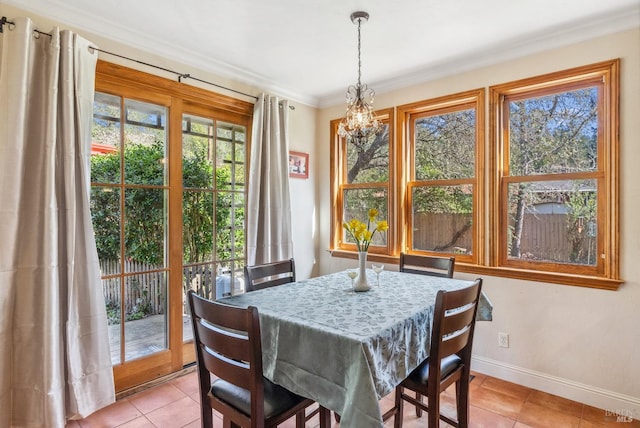 dining space featuring light tile patterned floors, a chandelier, baseboards, and ornamental molding