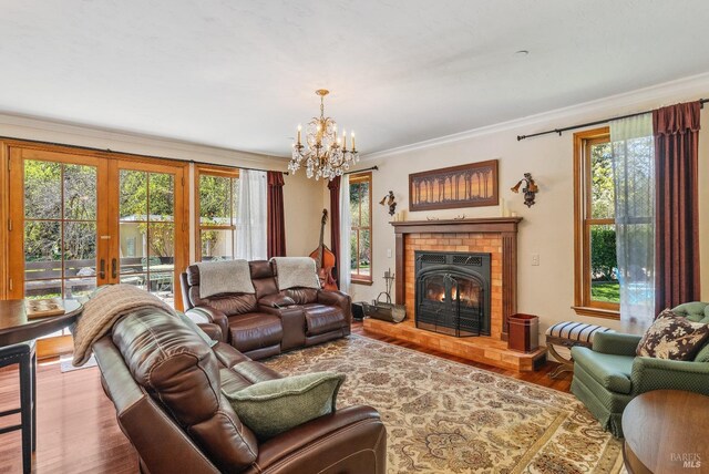 living area with a wealth of natural light, wood finished floors, ornamental molding, and a fireplace