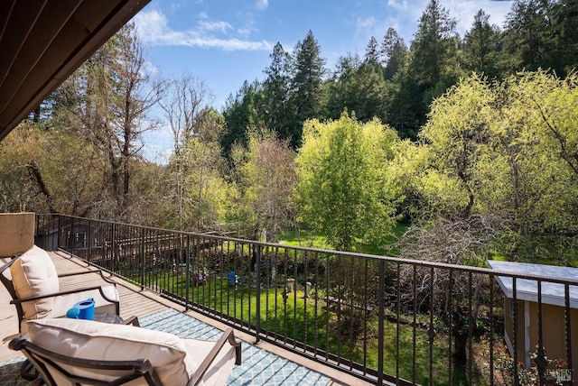 balcony featuring a forest view